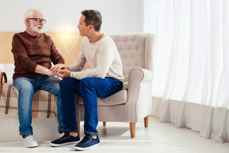 Male conversation. Serious young man sitting in semi position and touching hands while looking forward