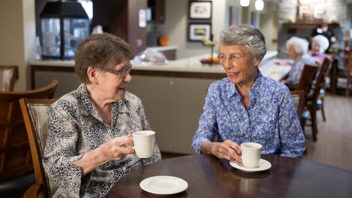 two senior women enjoying coffee together