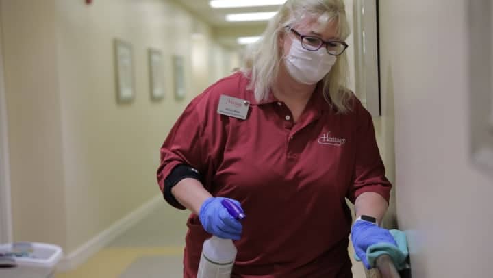 A Heritage staff member sanitizing the community