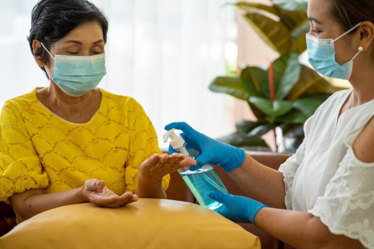 Senior Asian woman in hospital with daughter taking care with protective face mask. Health care and medicine concept.