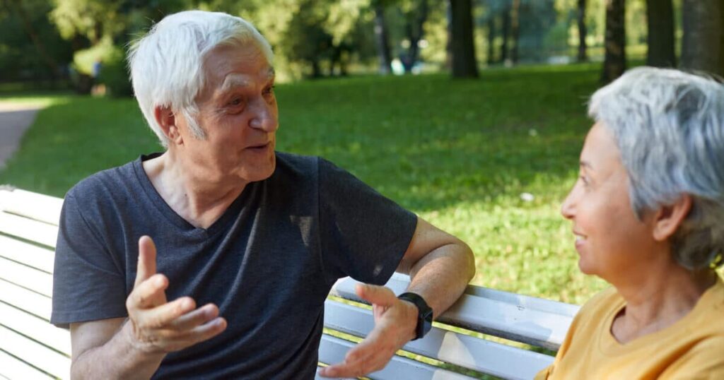 Two people on bench having a conversation ways to make new friends in senior living