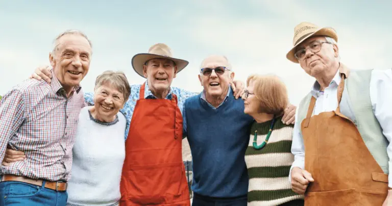 Group of elders hanging outdoors during retirement with their arms around each other