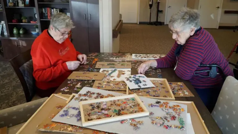 Two senior friends working on a puzzle at a Heritage Community.