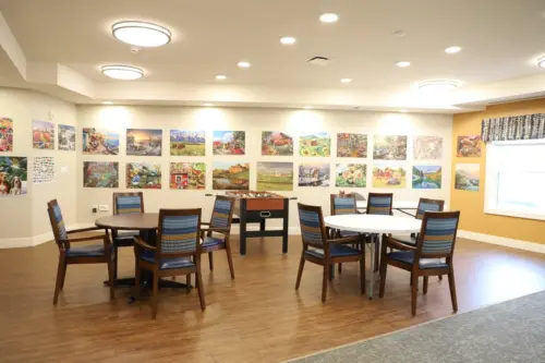 The Heritage at Fox Run activities room with completed puzzles as artwork