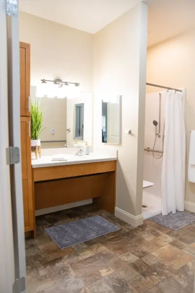 The Heritage at Legacy Bathroom vanity and shower at an assisted living apartment