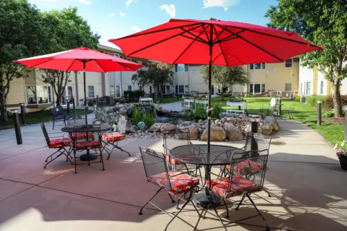 The Heritage at Meridian Gardens patio tables and umbrellas in secure outdoor courtyard